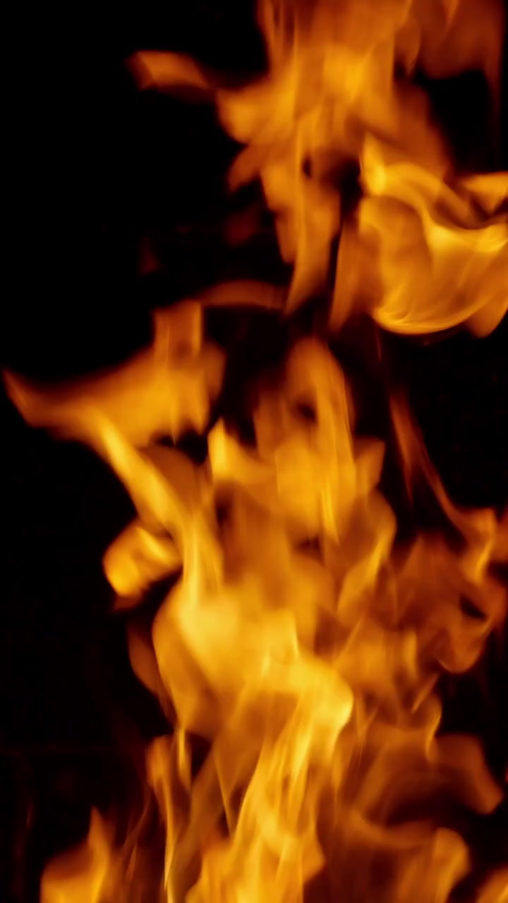 Fiamme di fuoco arancioni brillanti che bruciano su sfondo nero