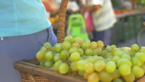 uvas verdes maduras y melocotones en cestas de mimbre