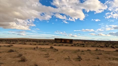 cabaña de remolque abandonada en el desierto de mojave junto a un arroyo caché lleno de agua turbia después de una tormenta - paso elevado aéreo