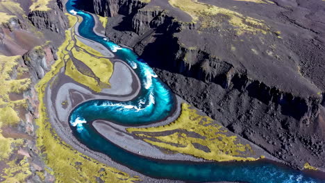 stunning aerial view of a vibrant blue river winding through a barren landscape
