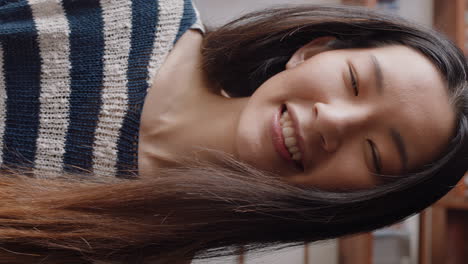 아름다운 아시아 여성이 스마트 폰을 사용하여 비디오 채팅을하고 수직 화면에서 온라인 커뮤니케이션을 즐기는 생활 방식을 공유하는 수화 언어를 사용하여 친구와 채팅하고 있습니다.