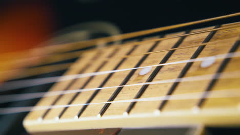 professional guitarist examines new brown acoustic guitar