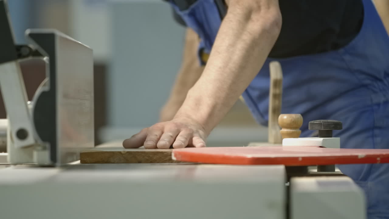 Falegname che lavora una tavola di legno con una pialla