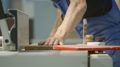 carpintero trabajando en una tabla de madera con una plancha