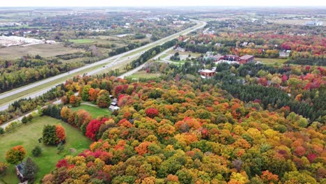 Experimente-La-Serena-Belleza-De-Un-Día-Nublado-De-Otoño-Mientras-Un-Dron-Se-Eleva-Sobre-Una-Carretera-Boscosa,-Capturando-Impresionantes-Vistas-Desde-Arriba