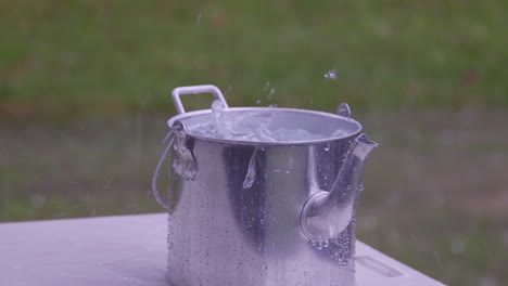 rainwater fills a kettle or billy outside during a storm