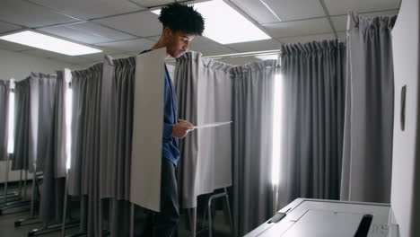 a person casts their vote at a polling place