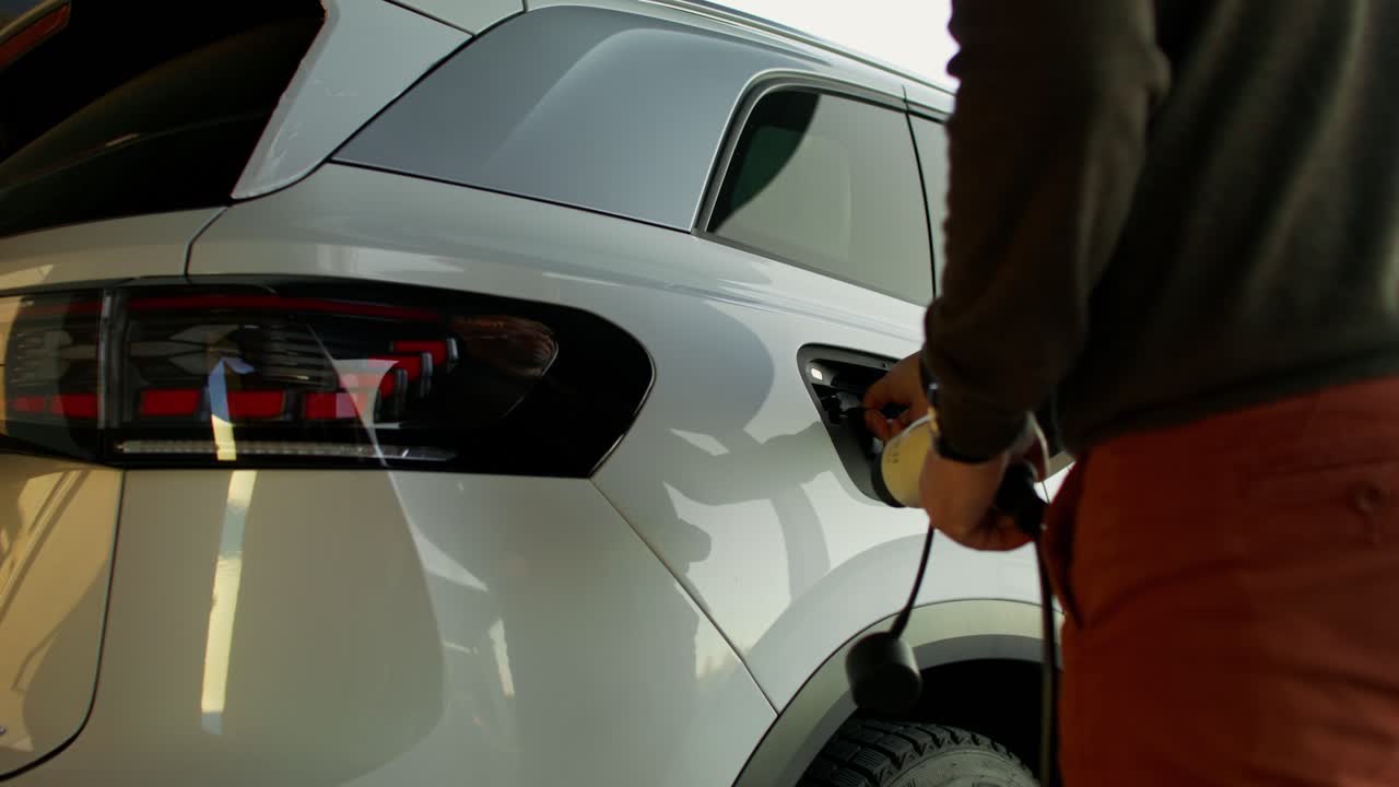 persona cargando un suv eléctrico