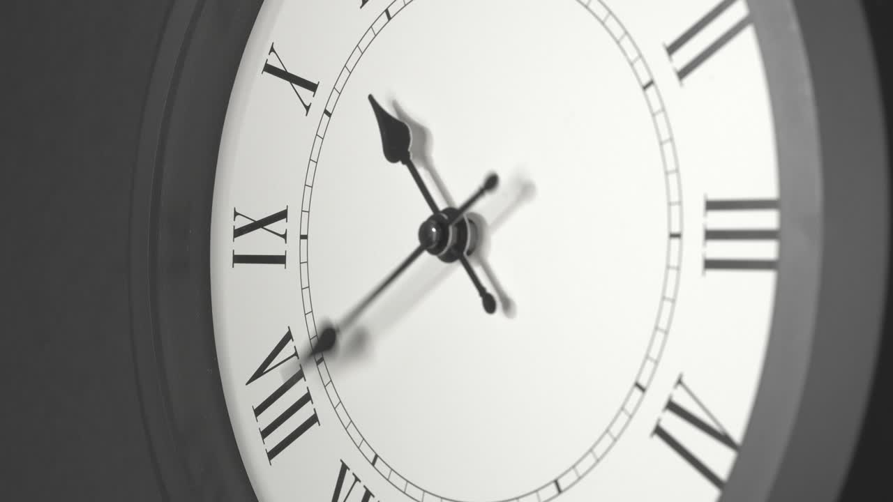 Latin Clock Face in Time Lapse on Dark Grey Wall