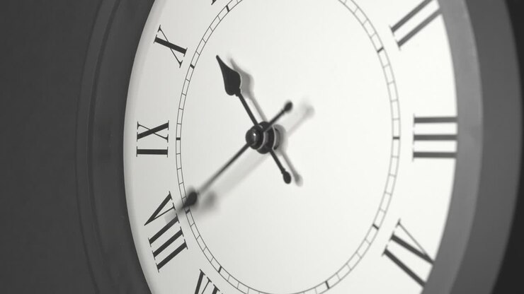 Latin Clock Face in Time Lapse on Dark Grey Wall