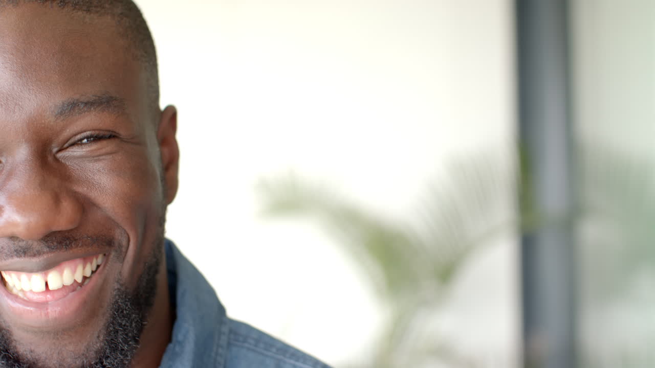 Smiling African American man relaxing at home, enjoying leisure time, copy space
