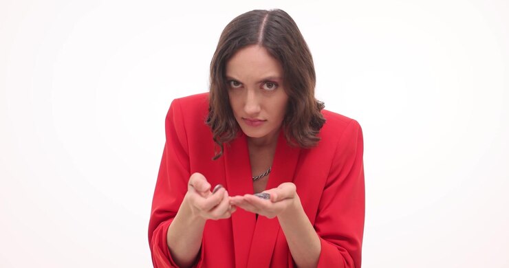 Woman looks intently at coins holding in cupped hands counting