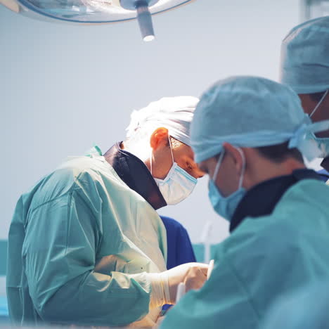 portrait of a doctor in a mask with men assistants in clinic. group of neurosurgeons performing an operation in medical center.
