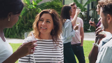 Group-Of-Multi-Cultural-Friends-Relaxing-And-Drinking-Wine-In-Garden-Together