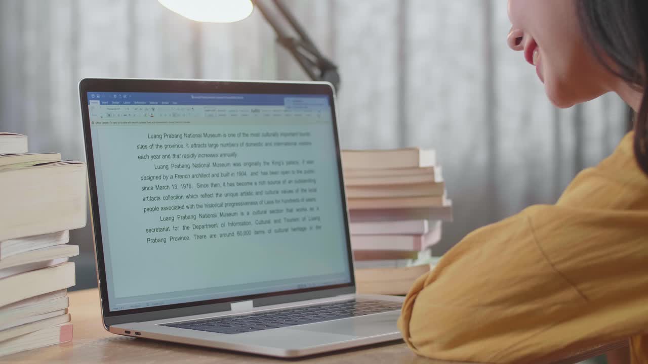 mujer estudiando en una computadora portátil con libros