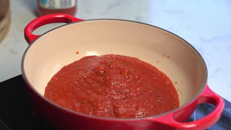 preparing meatless tomato sauce in pot in home kitchen, close up