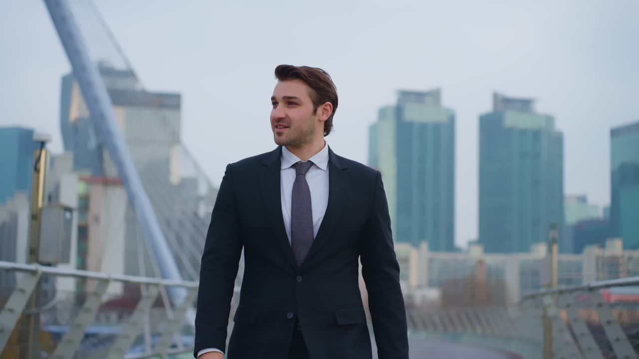 Determined male entrepreneur in suit walking across modern bridge with Seoul skyline in backdrop during dolly back slow motion shot representing future success and business vision