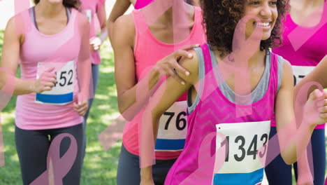 animation of multiple pink ribbon logo over diverse group of smiling women