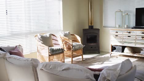 house interior of sunny living room with two chairs, tv and fireplace