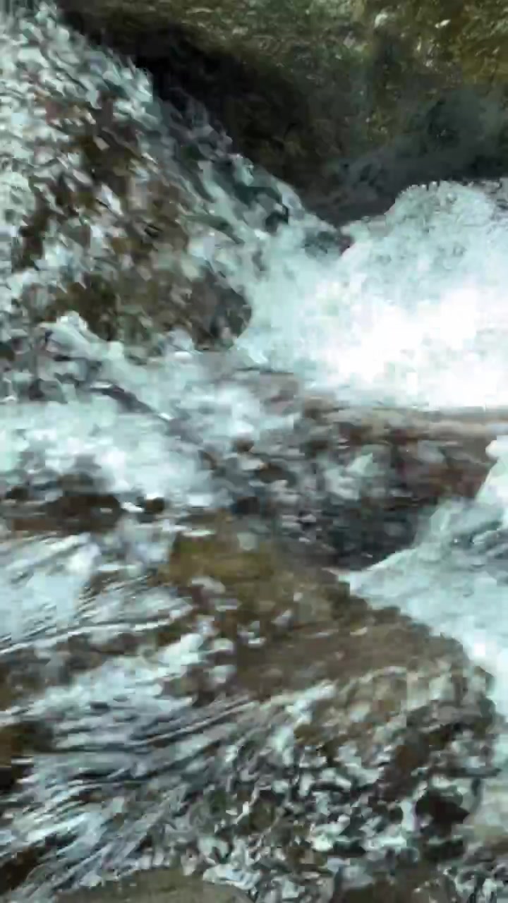 Acqua limpida di ruscello di montagna che scorre sulle rocce