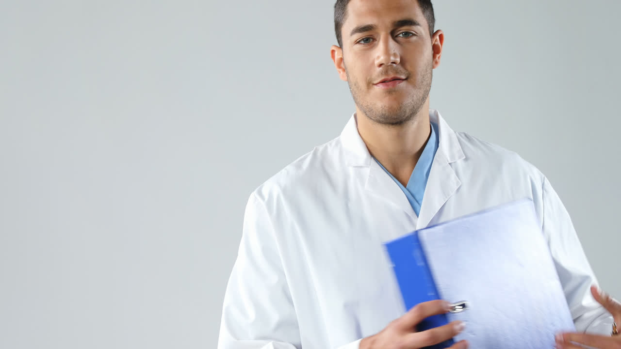 Medico sorridente che scrive rapporti nella cartella 4K