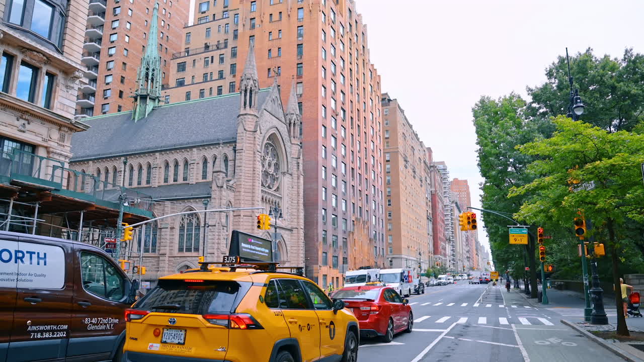 New York, USA, 4 August 2025: Street view with historic church and traffic in New York. Busy street in Manhattan featuring a historic stone church, yellow taxis