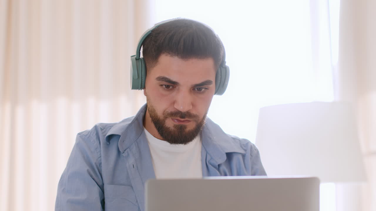 Man working on a laptop with headphones