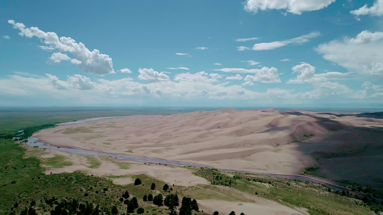 drone vista lejana de montañas de arena suave y un río en colorado