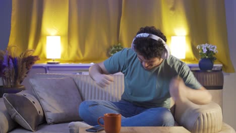 man dancing at night while listening to music at home.