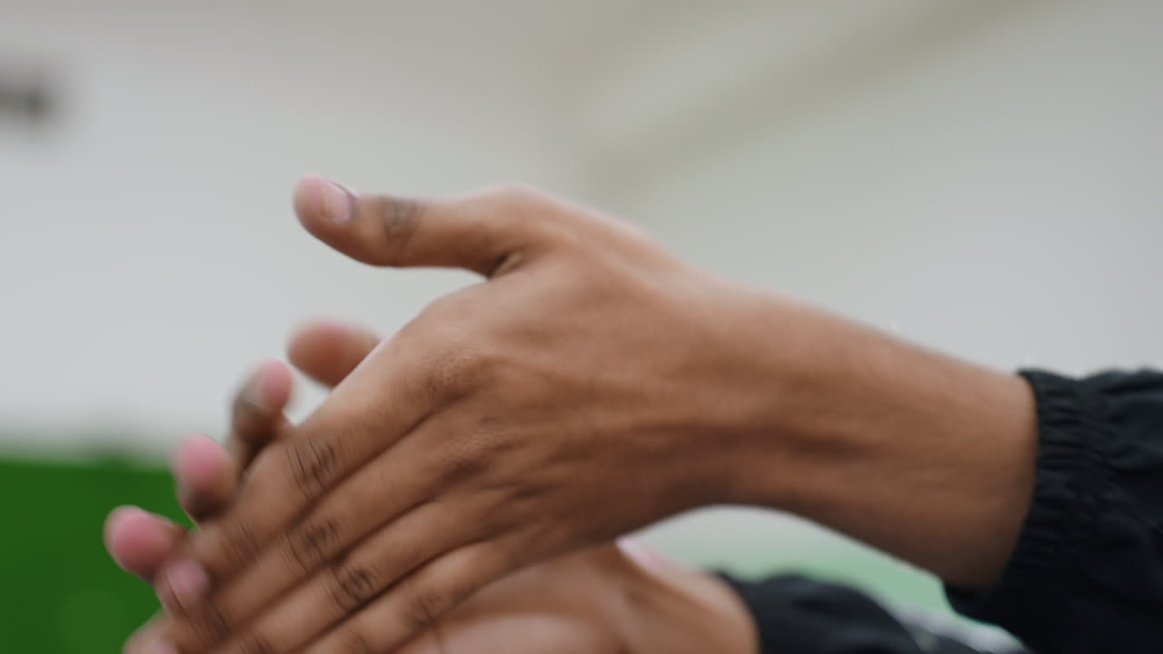 Close up hand view of athlete practicing wrist flexibility during indoor workout session focusing on control, movement, and preparation for sports activity with background slightly blurred