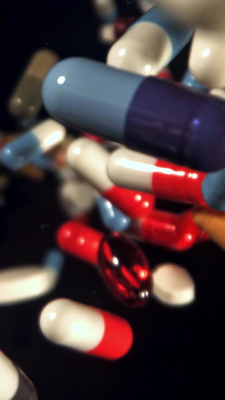 Assortimento di pillole e capsule colorate che cadono al rallentatore