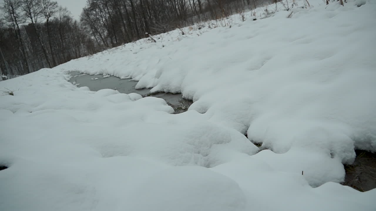 하얀 눈 덮인 풍경, slowmo 한가운데 얼어붙은 강에서 돌리
