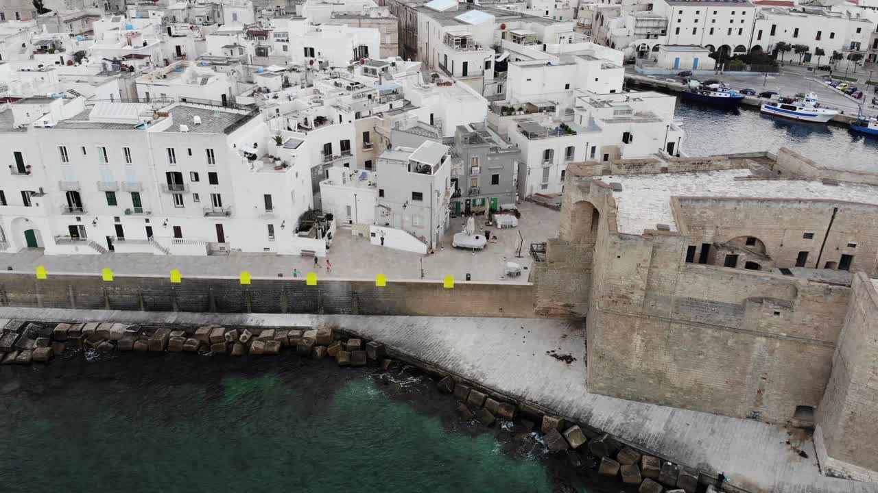 drone vuela desde el mar sobre el castillo de monopolio y el centro de la ciudad vieja durante el amanecer