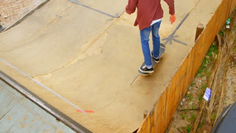 Vista-De-ángulo-Alto-De-Un-Joven-Haciendo-Truco-De-Patineta-En-El-Borde-De-La-Rampa-De-Patineta-En-La-Cancha-De-Patineta-4