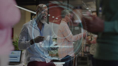 animation of cyber security text, magnifying glass icon over african american man laughing at office