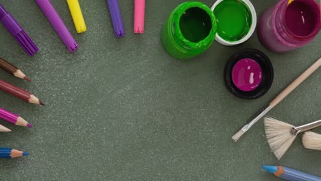 animation of watercolour paints, paintbrushes, coloured pencils and pens on table top