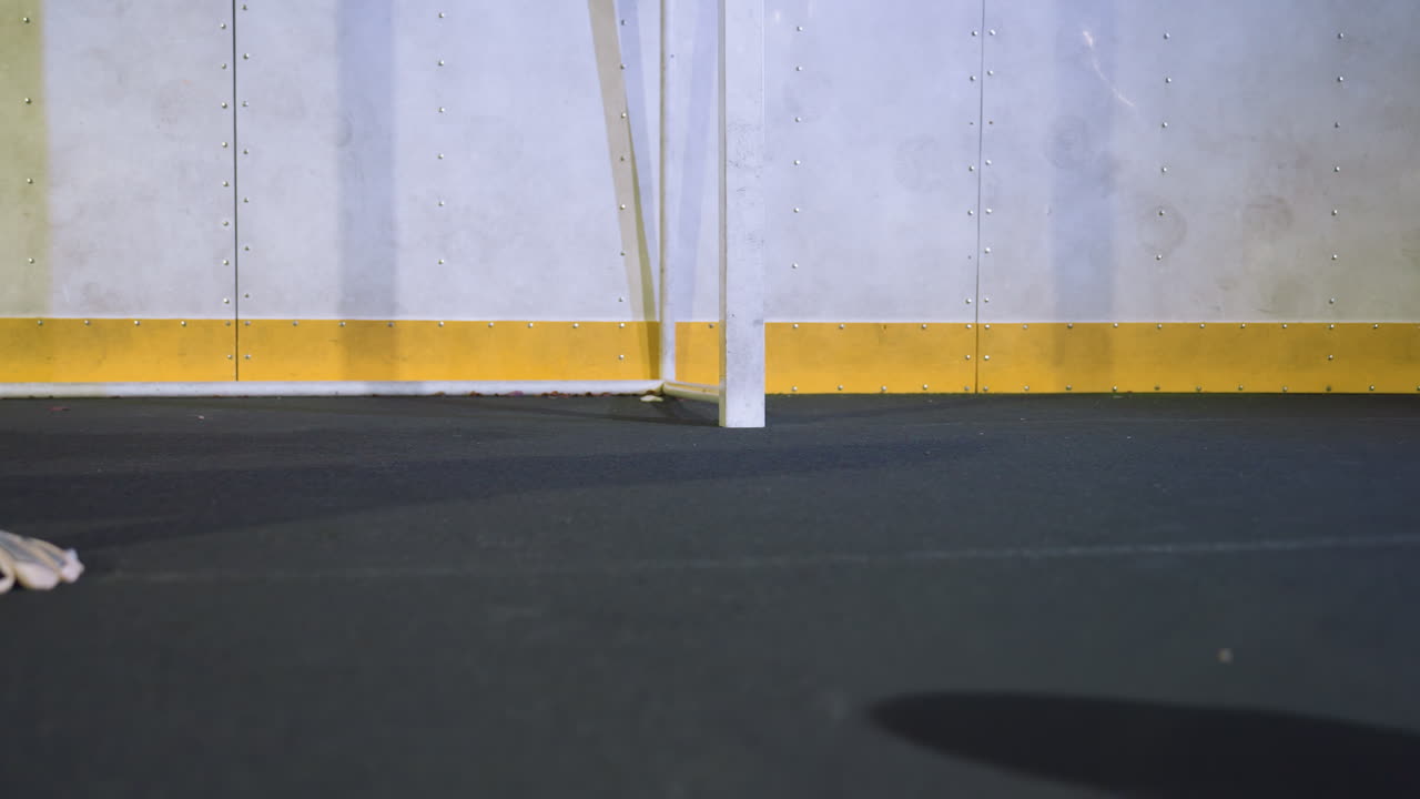 joven atleta se sumerge en el suelo para atrapar una pelota de fútbol que se mueve rápidamente en el lado izquierdo durante una sesión de entrenamiento intenso, mostrando agilidad y precisión atlética en un entorno deportivo bien iluminado