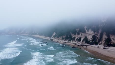 aerial drone shot of a misty ocean shoreline in sedgefield, a popular travel destination along the garden route in the western cape, south africa