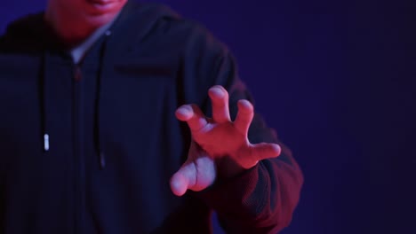 midsection of asian man, touching virtual screen on blue background, slow motion