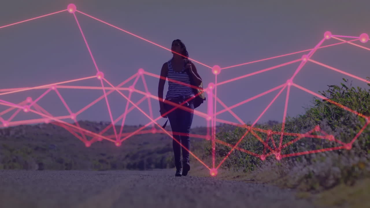 woman hiker walking rural road, projecting neon-pink mesh overlay for technology visualization
