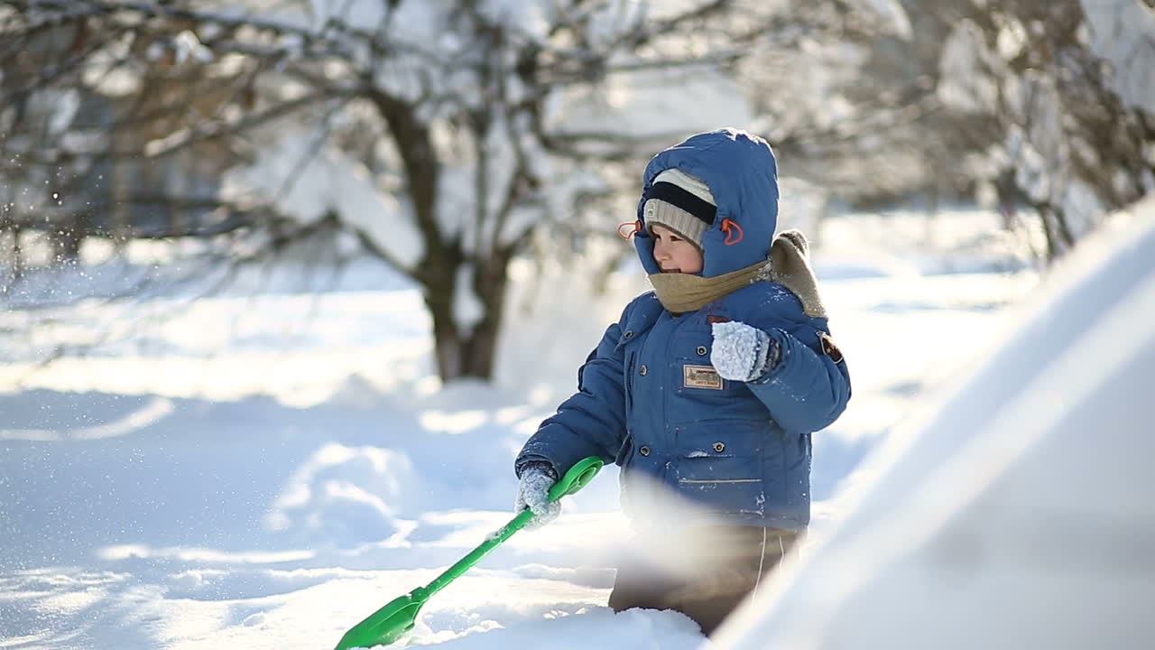 Mother with son walking on snow. Little boy with mother walking in snowy winter day