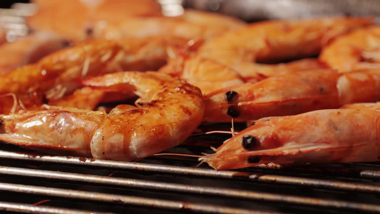 Chef cooking shrimps with oil and spices on grill close-up. Prawns on fire throwing them on pan. Restaurant Food concept. Sea food barbecue.