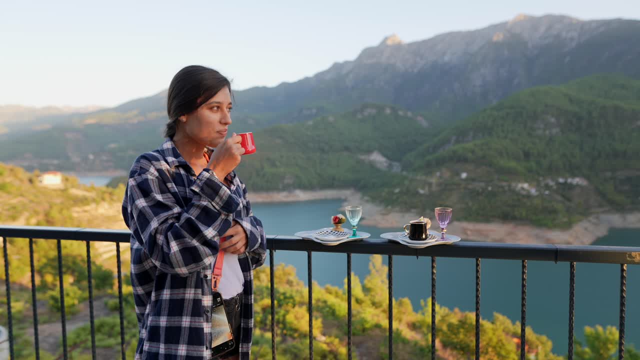 Mulher apreciando café em uma varanda com vista para a montanha