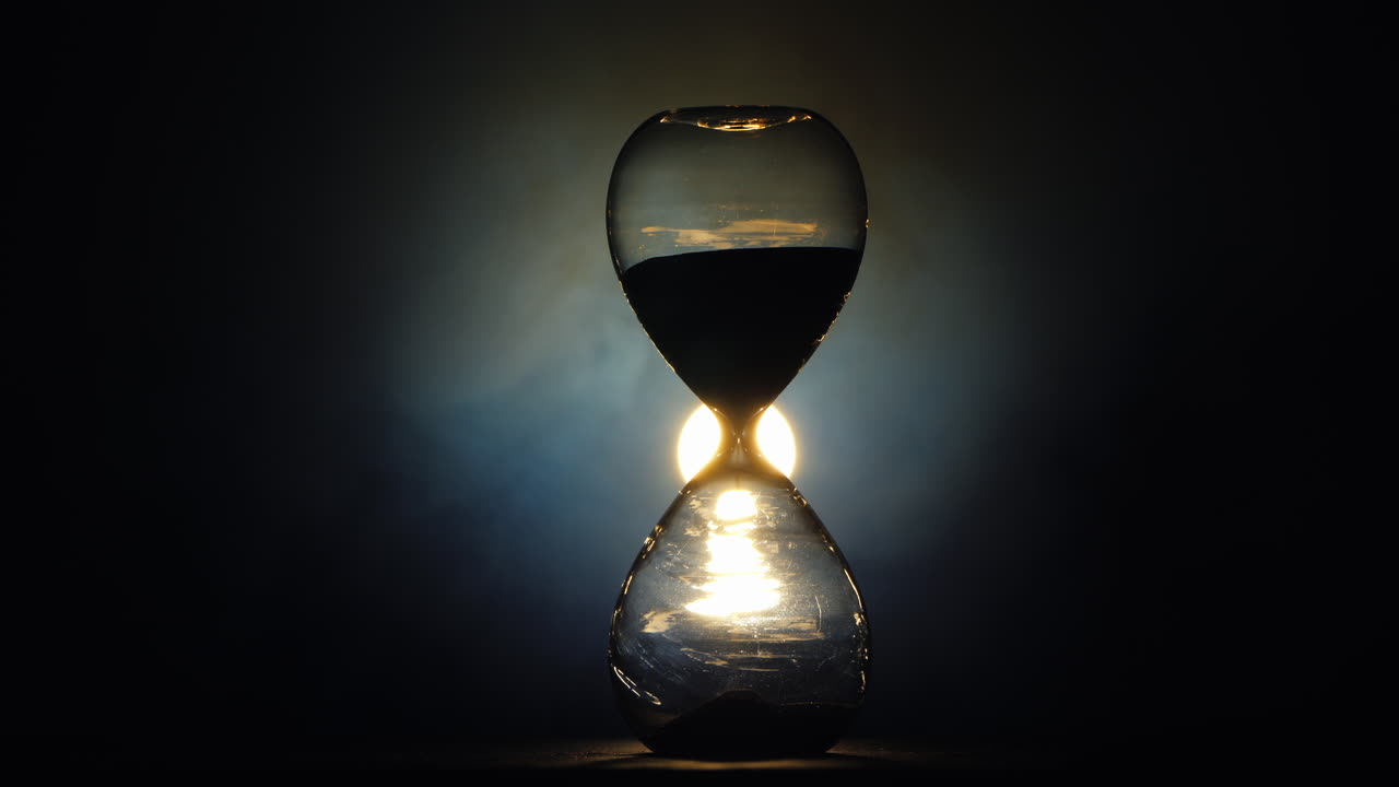 La luce tremolante illumina la vecchia clessidra