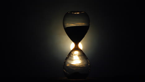 the flickering light illuminates the old hourglass