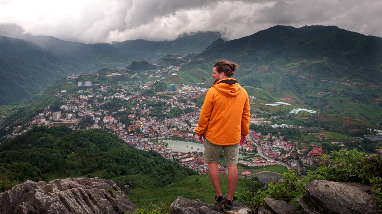 Vandrer på toppen av Ham Rong-fjellet (Dragekjeven) med utsikt over turistbyen Sapa i Vietnam