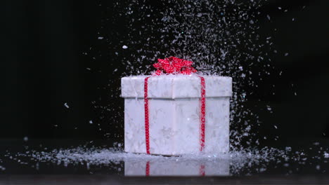 glitter falling onto christmas present in slow motion