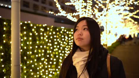 Joven-Japonesa-De-Piel-Clara-Paseando-Por-Un-Camino-Bellamente-Iluminado-En-Tokio,-Japón---De-Cerca