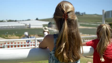 girls looking at their friend riding horse 4k