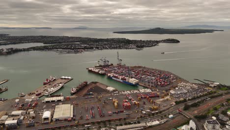 industrial port and harbor of auckland at sunset. cranes loading container on ships. aerial view